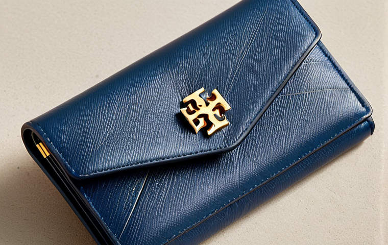 Tory Burch Kira Wallet**

"Close-up studio shot of a Tory Burch Kira Wallet, fully closed, showcasing its minimalist design on a neutral surface. The wallet is made of high-quality leather with clean stitching. Background is blurred to focus on the wallet. safe for work, appropriate content, fully clothed (wallet has no implied figure), professional product photography, perfect condition, high quality."

**